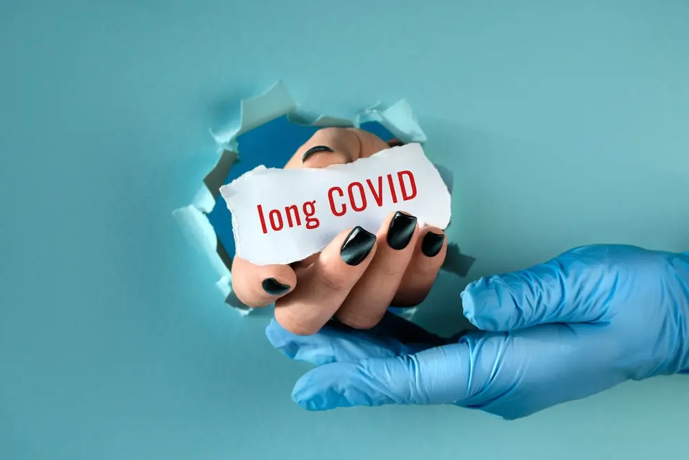 Long COVID, post-COVID syndrome, with a hand in a glove representing ongoing health concerns.