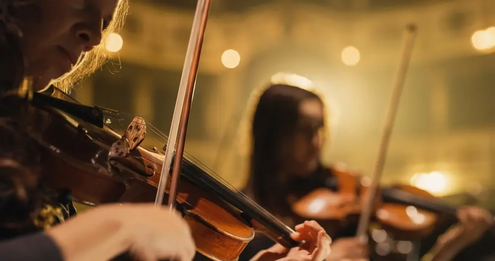 Cinematic close-up shot of a professional symphony orchestra violin player.