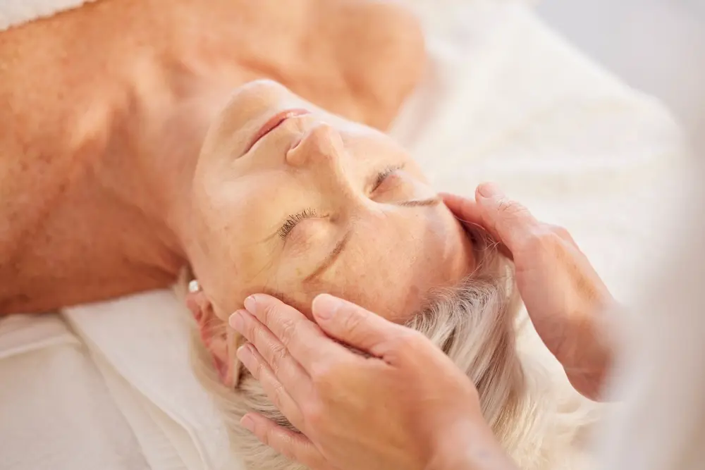 Senior woman receiving a head massage at a spa.