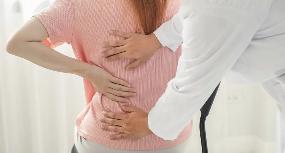 Female patient consulting physiotherapists for an examination due to low back pain.